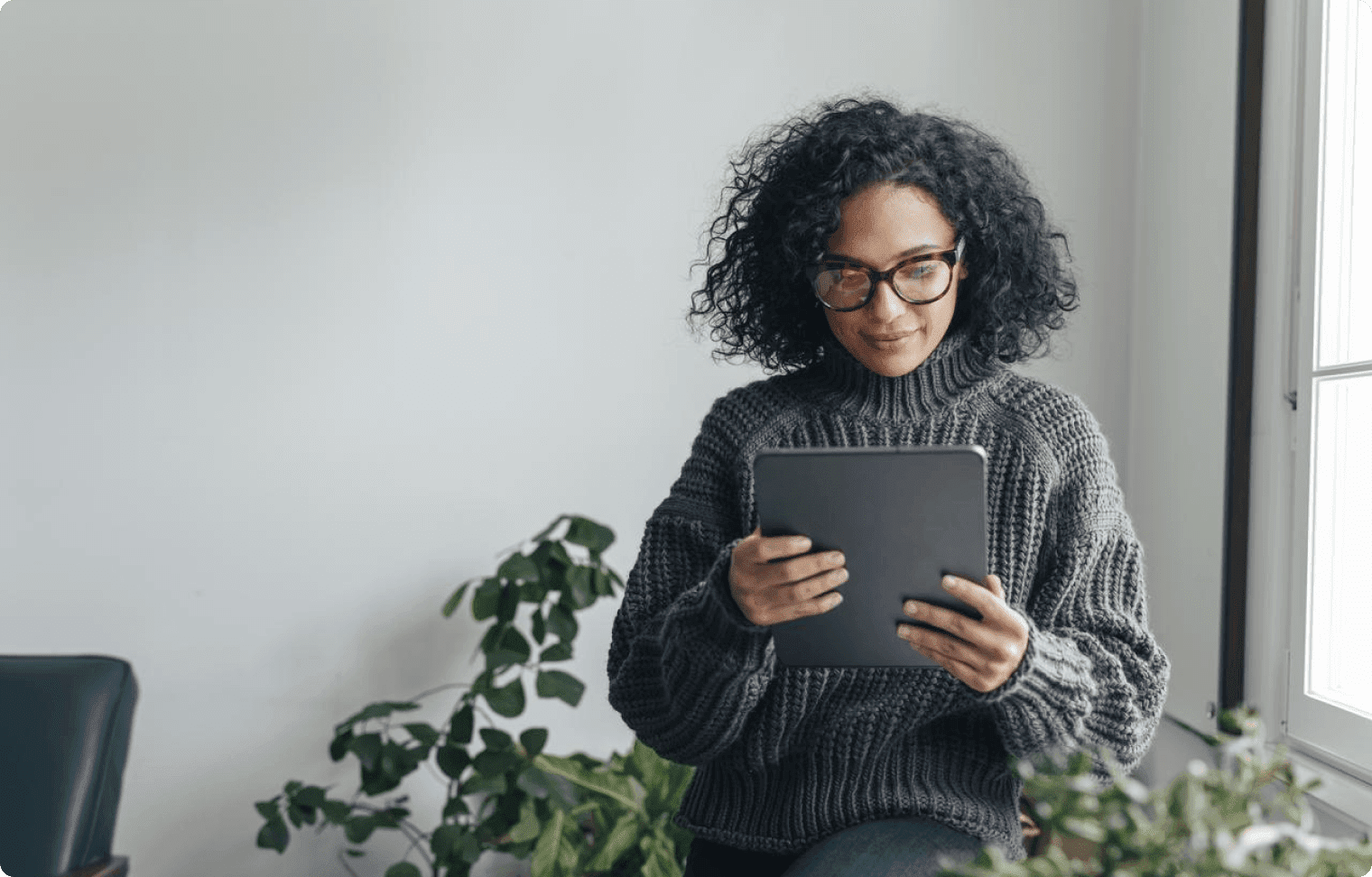 The woman with a tablet gets better answers through chatbot customer service interaction powered by Coveo.