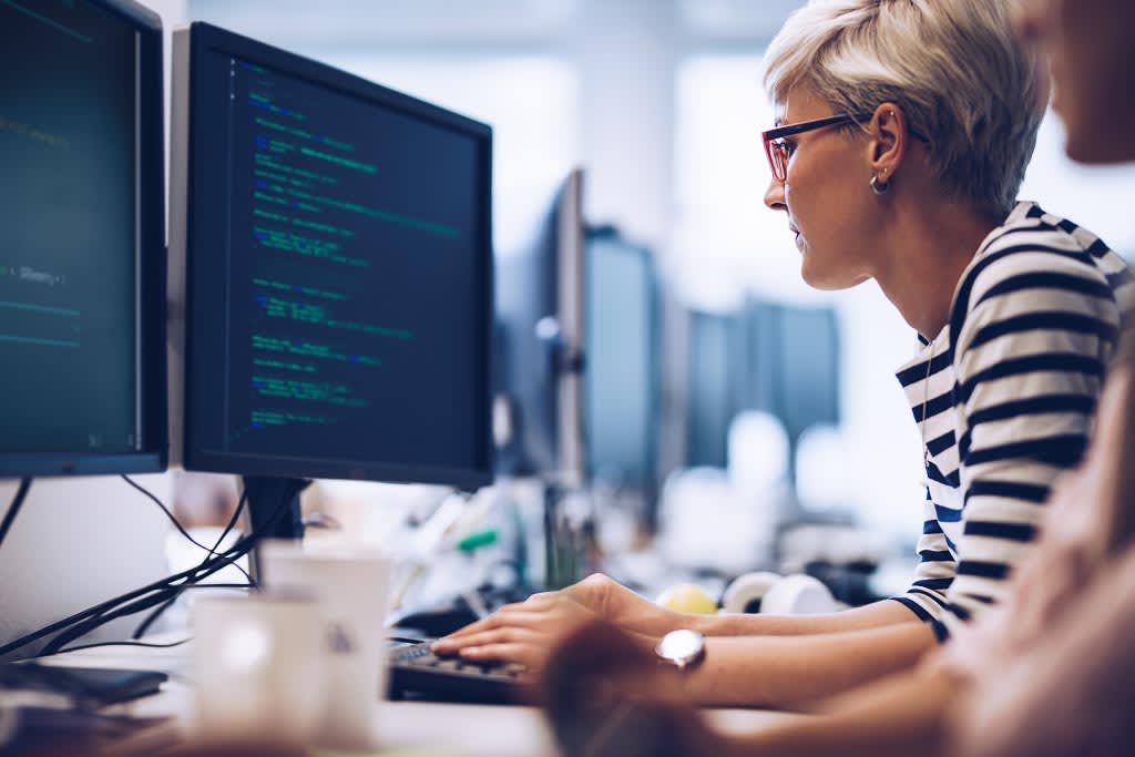 Short haired computer programmer working on a new software in the office.