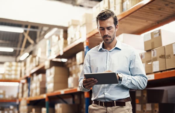 Shot of a young man using a digital tablet while working in a warehouse